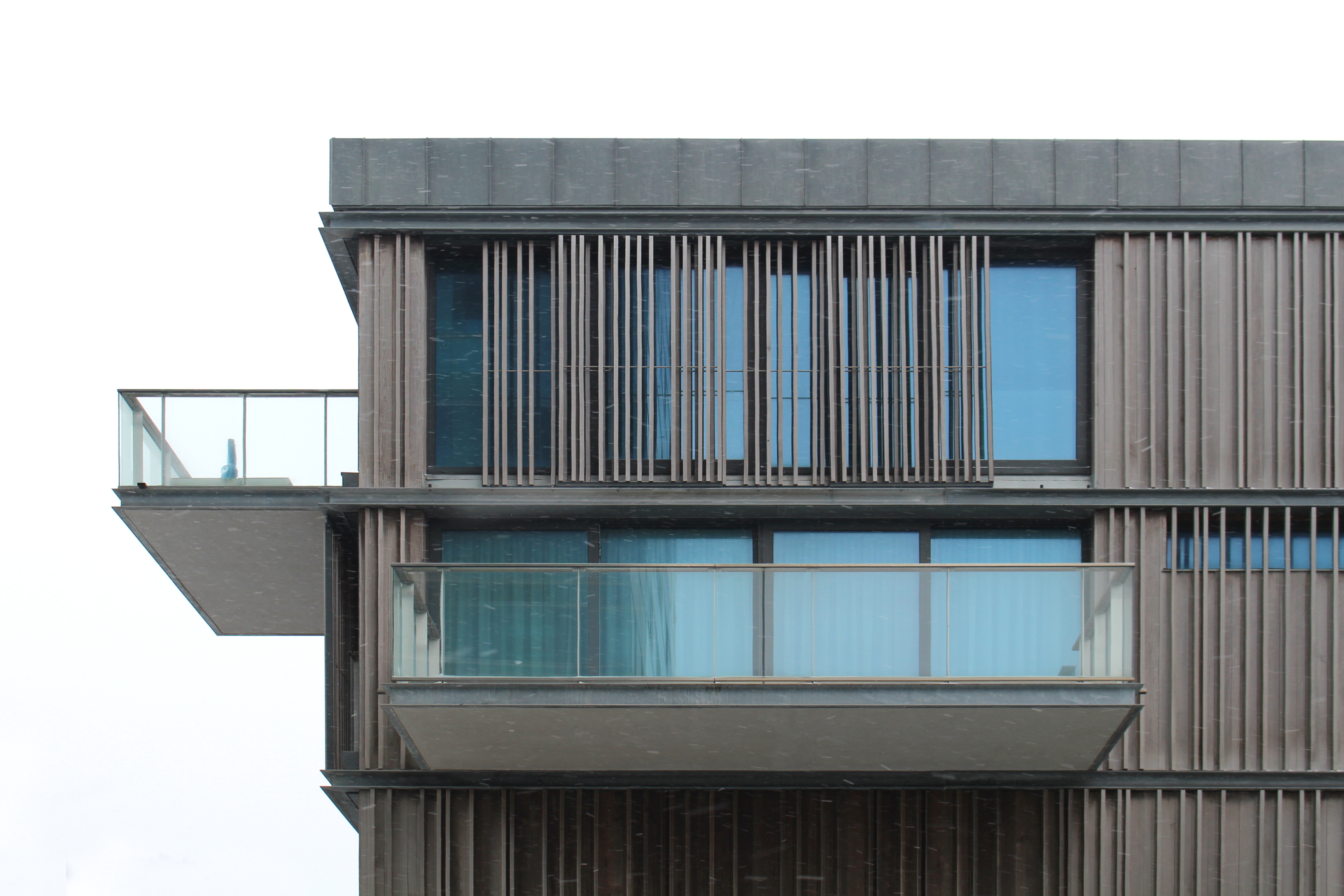 Detail of the sliding wooden cladding system applied to the cantilevered terraces.